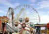 Colorful amusement park scene featuring a ferris wheel and carousel