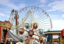 Colorful amusement park scene featuring a ferris wheel and carousel