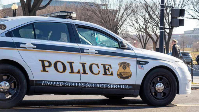 1606745311-1 United States Secret Service police car on roadside.