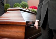 Pallbearer holding a wooden casket handle