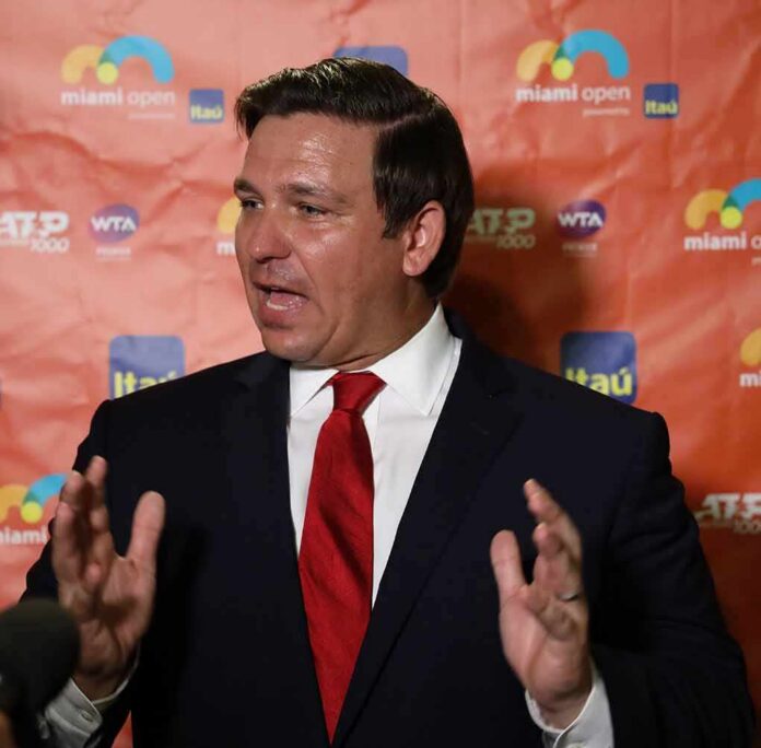shutterstock_1374801944 Man in a suit speaking at a media backdrop