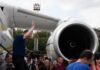 Zelenskyy’s Plane Attacked By Drone Amid Takeoff Group of people gathered near a large airplane engine