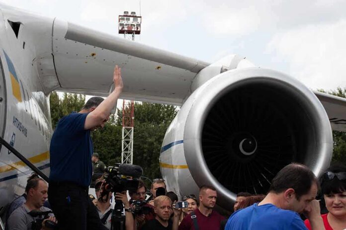 shutterstock_1498114295 Group of people gathered near a large airplane engine
