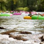 People floating on colorful inner tubes in a river