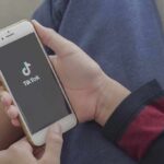Hands holding a smartphone with a short-video app loading screen