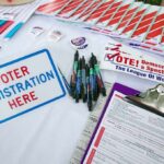 DHS Sting Backfires – Citizens Flagged as “Illegal” Voter registration table with forms, pens, and informational materials