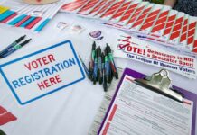DHS Sting Backfires – Citizens Flagged as “Illegal” Voter registration table with forms, pens, and informational materials