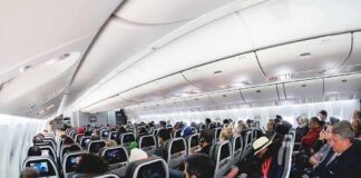 Airplane cabin with passengers seated in economy class