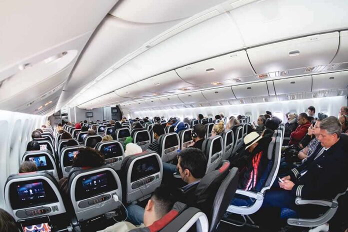 shutterstock_2013481865 Airplane cabin with passengers seated in economy class