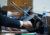 Feds Investigate Newsom: Criminal Paper Trail Emerges Person pressing a button on a conference microphone panel