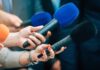 Dem Candidate Attack Crumbles After Controversial Video Released Reporters holding colorful microphones
