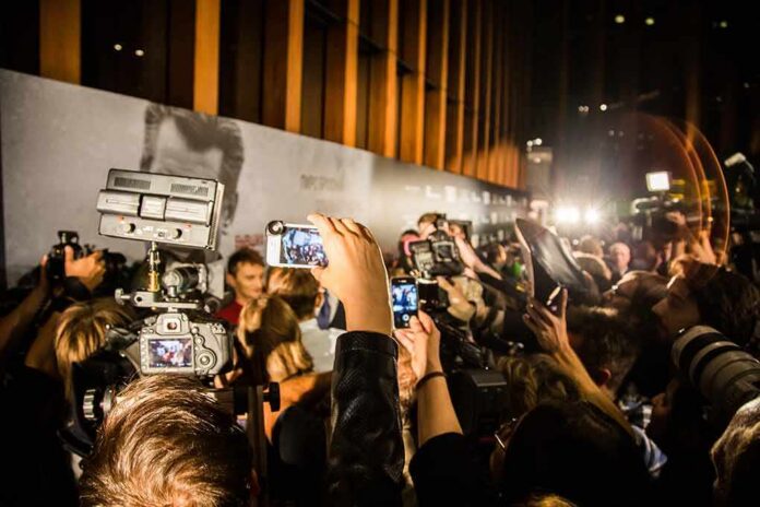 Crowd of photographers and reporters with cameras at a red carpet event