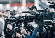 84 Years Later: WW2 Body Comes Home Broadcast cameras on tripods at a press event