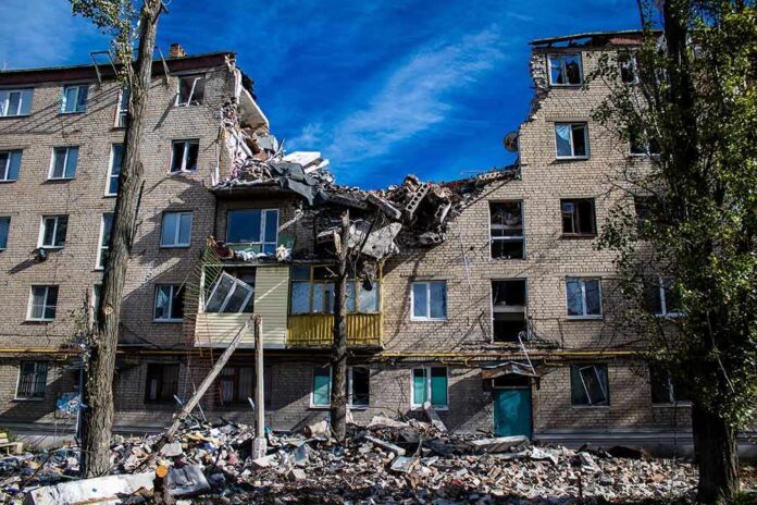 Damaged apartment building with collapsed upper floors and debris