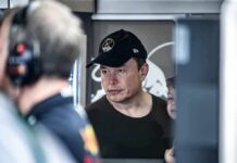 Musk’s War Chest Comes Saves GOP Midterms Elon Musk wearing a black cap in a crowded indoor setting