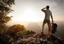 Hiker Impaled By Pole – Then Walked 10 Miles Hiker standing on a rocky outcrop overlooking a valley at sunset