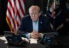 Bestiality Accusation Hijacks Trump – Shocking! Person in suit seated at table with telephones