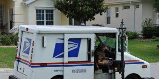 USPS mail truck parked at a suburban mailbox