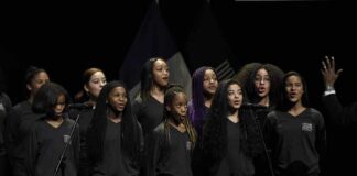 Sikhanyiso Dlamini with a youth choir singing on stage