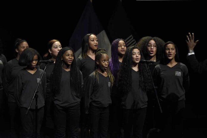 Sikhanyiso Dlamini with a youth choir singing on stage