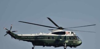 Green and white helicopter in flight