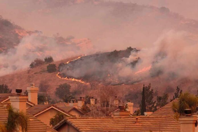 shutterstock_735803347 Wildfire burns on hillside near suburban homes