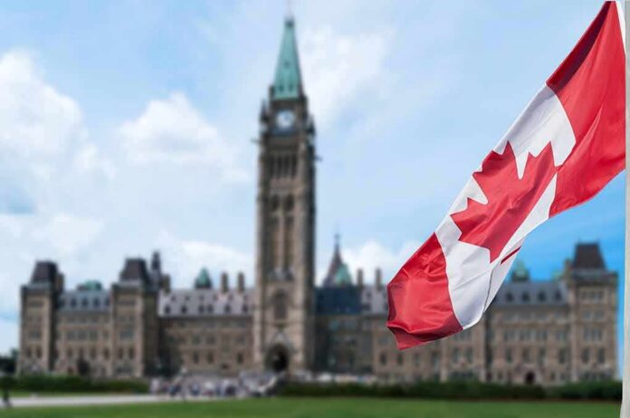 shutterstock_747320905 Canadian flag with Parliament building in background