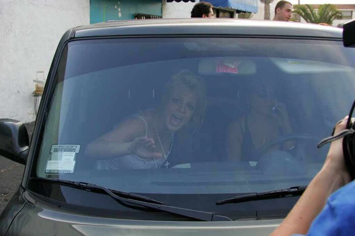 Britney Spears gestures from inside a car behind the windshield