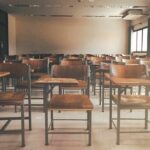 Protest Erupts: Tear Gas Drowns Classrooms Fight Empty classroom with rows of wooden desks and chairs