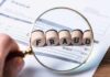 DEM CORRUPTION SCANDAL: Husband of Candidate ARRESTED! Magnifying glass highlighting wooden blocks spelling fraud on an invoice