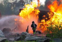 Military Inferno KILLS 4, Dozens Injured! Firefighter battling a large fire with water spray