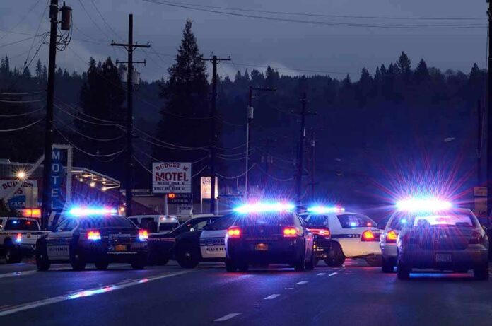 Police cars with flashing lights block a road at night