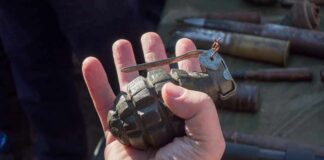 Hand holding a vintage hand grenade
