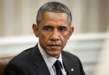 Worker Uprising Hits Obama Library Man in suit looking to the side, identified as Rob Nabors