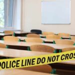 Woman Arrested Posing as Teacher and Hurling Racial Slurs at Kids Empty classroom with police tape across desks