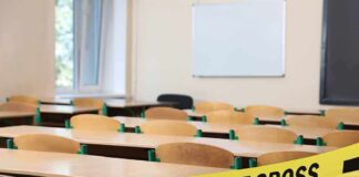 Empty classroom with police tape across desks