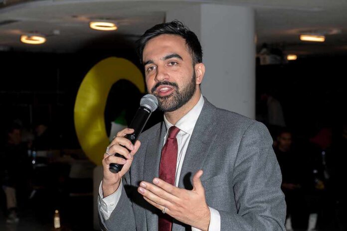 Zohran Mamdani speaking into a microphone